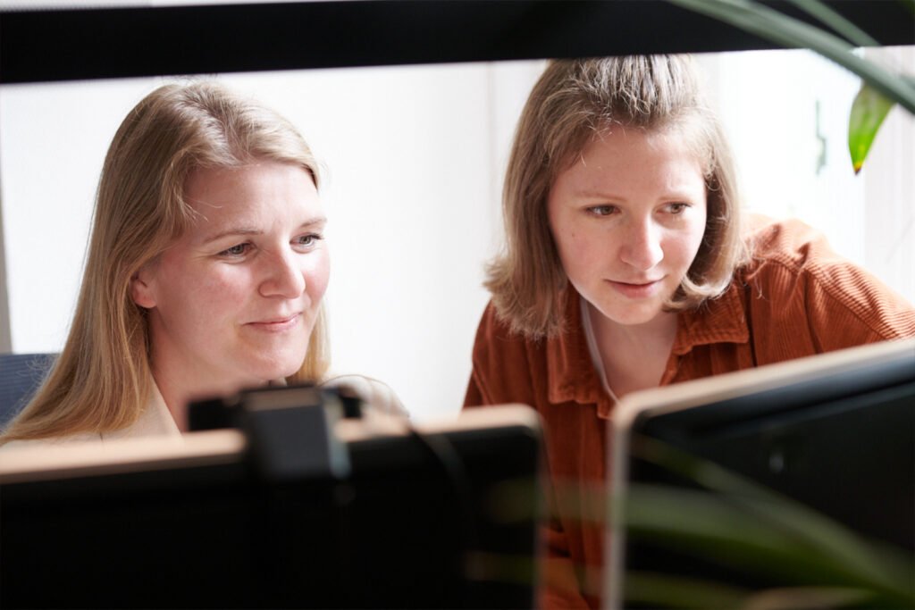 Zwei junge Frauen arbeiten konzentriert am PC.